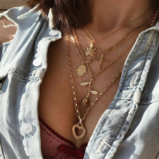 Mehrreihige Goldkette mit symbolischen Anhängern am Hals