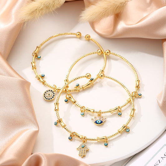 3 Glücksarmreifen im Gold-Look mit blauen Augen