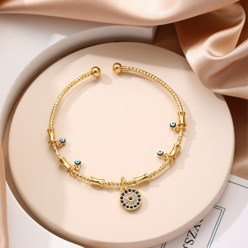 Glücksarmreifen im Gold-Look mit blauen Augen