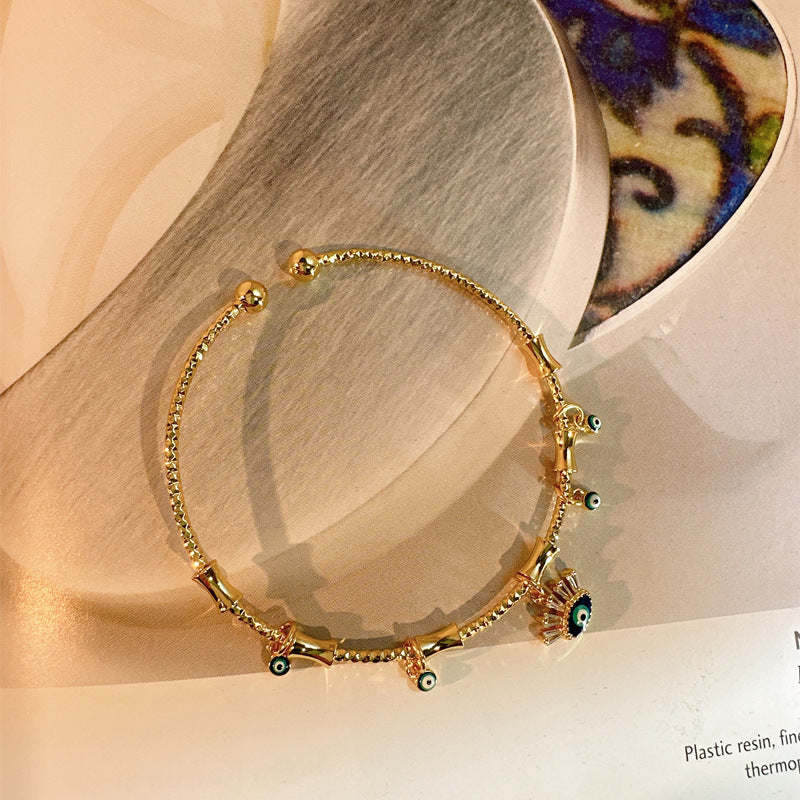 Glücksarmreifen im Gold-Look mit blauen Augen